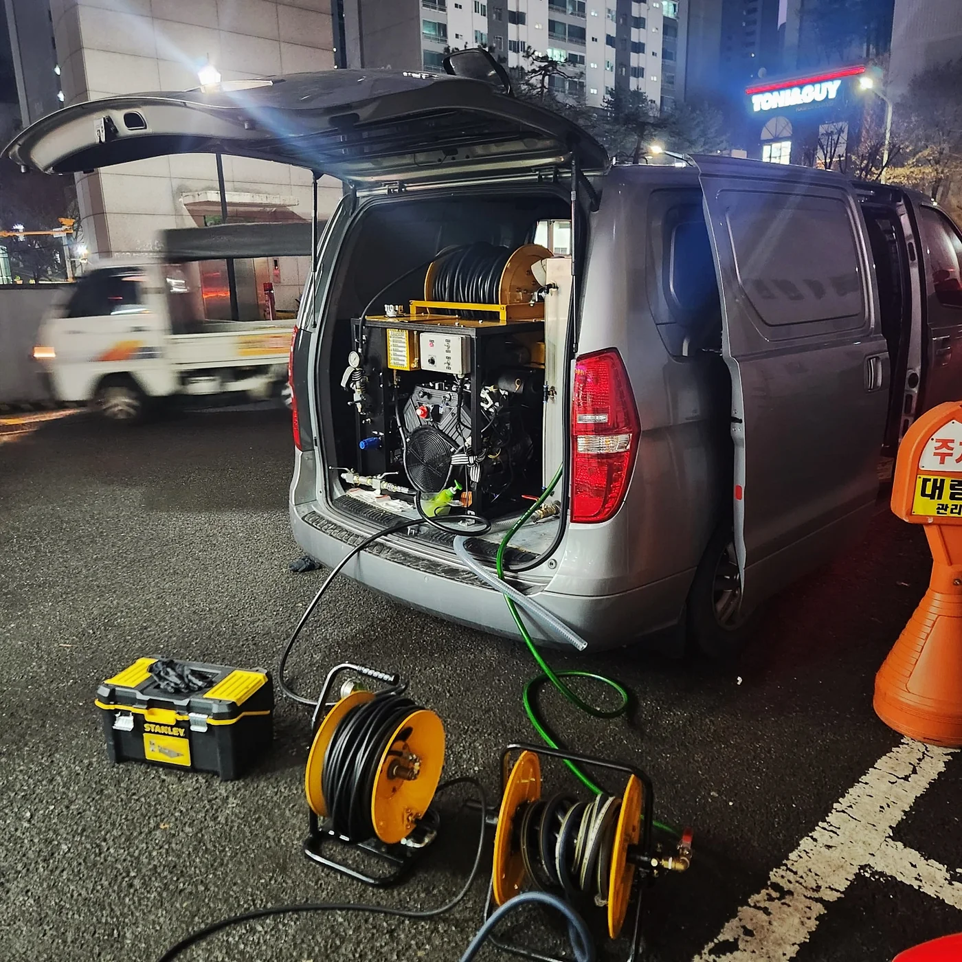 차량에 적재된 고압세척 장비와 호스